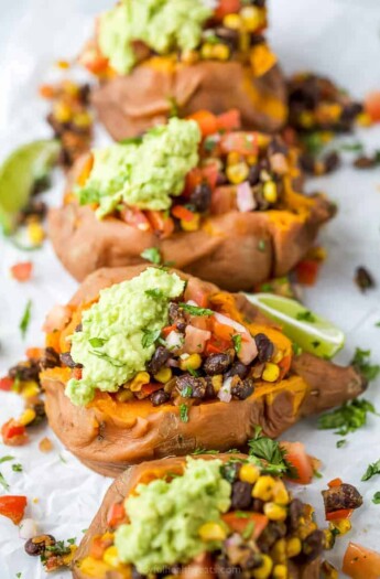 side photo of easy vegan black bean stuffed sweet potatoes with guacamole on top