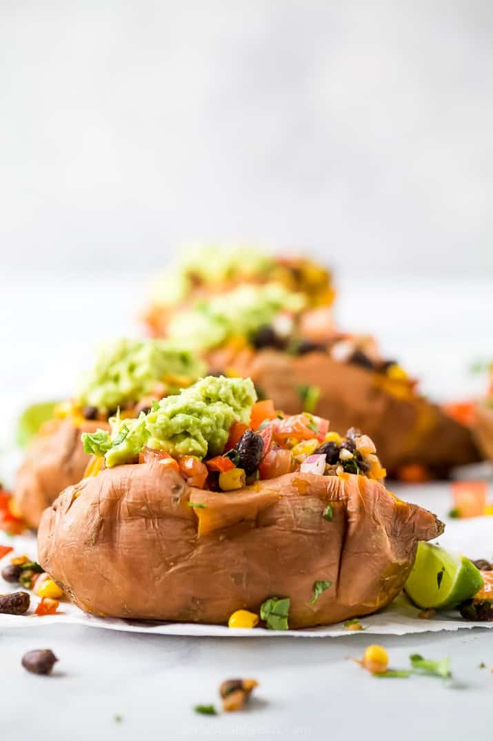 side photo of easy vegan black bean stuffed sweet potatoes with guacamole on top