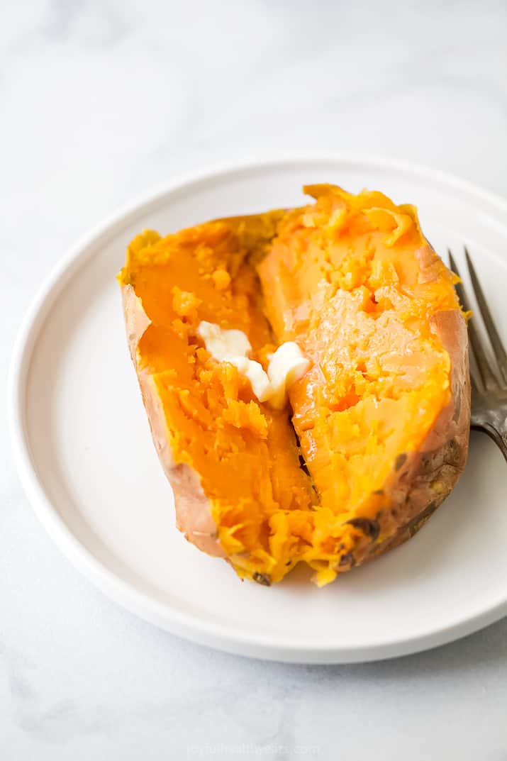 Close up photo of an instant pot sweet potato cut in half with butter.