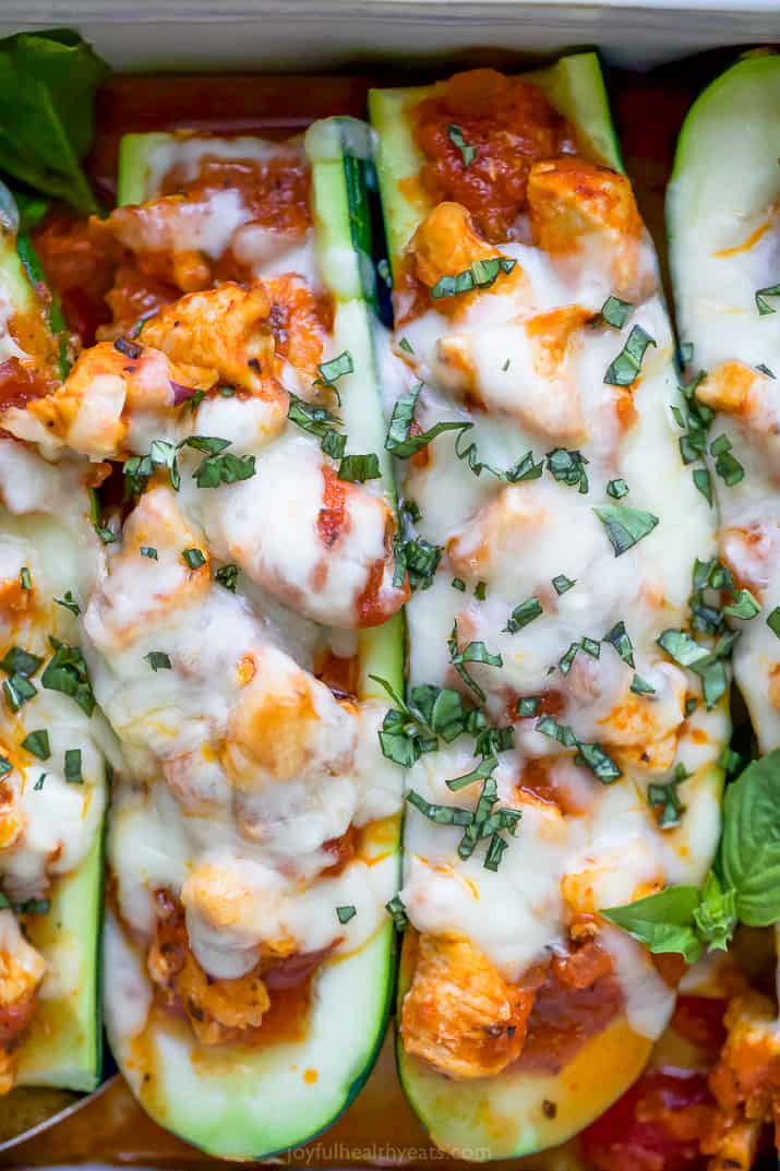 close up photo of the best easy chicken parmesan zucchini boats in a baking dish