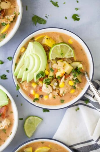 bowl filled with creamy crockpot chicken tortilla soup topped with avocado