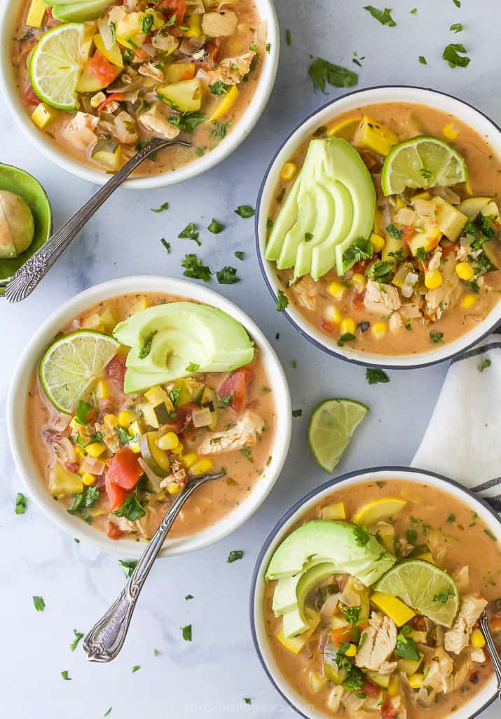 a group of bowls filled with creamy crockpot chicken tortilla soup
