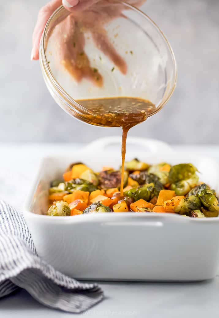 pouring dressing over roasted vegetables