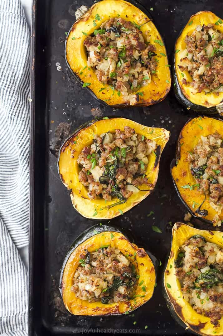 apple sausage stuffed acorn squash on a baking sheet