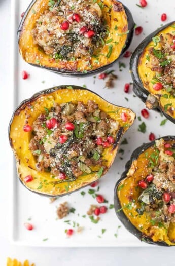 overhead photo of apple sausage stuffed acorn squash with pomegranate on top