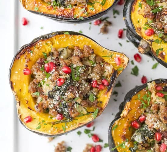overhead photo of apple sausage stuffed acorn squash with pomegranate on top