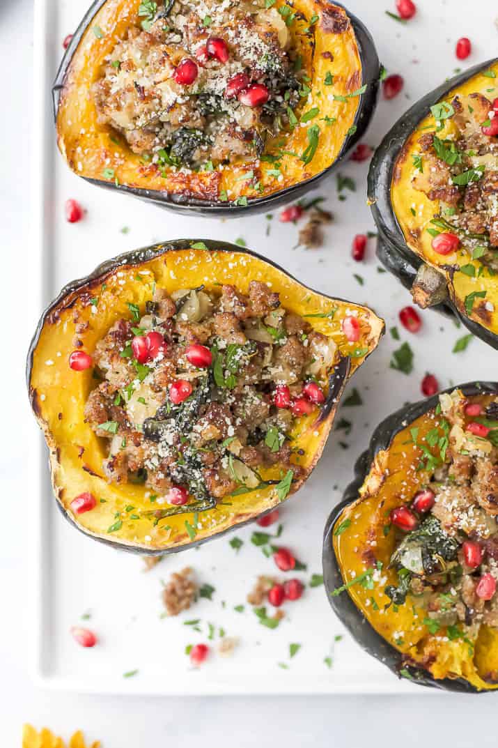 overhead photo of apple sausage stuffed acorn squash with pomegranate on top