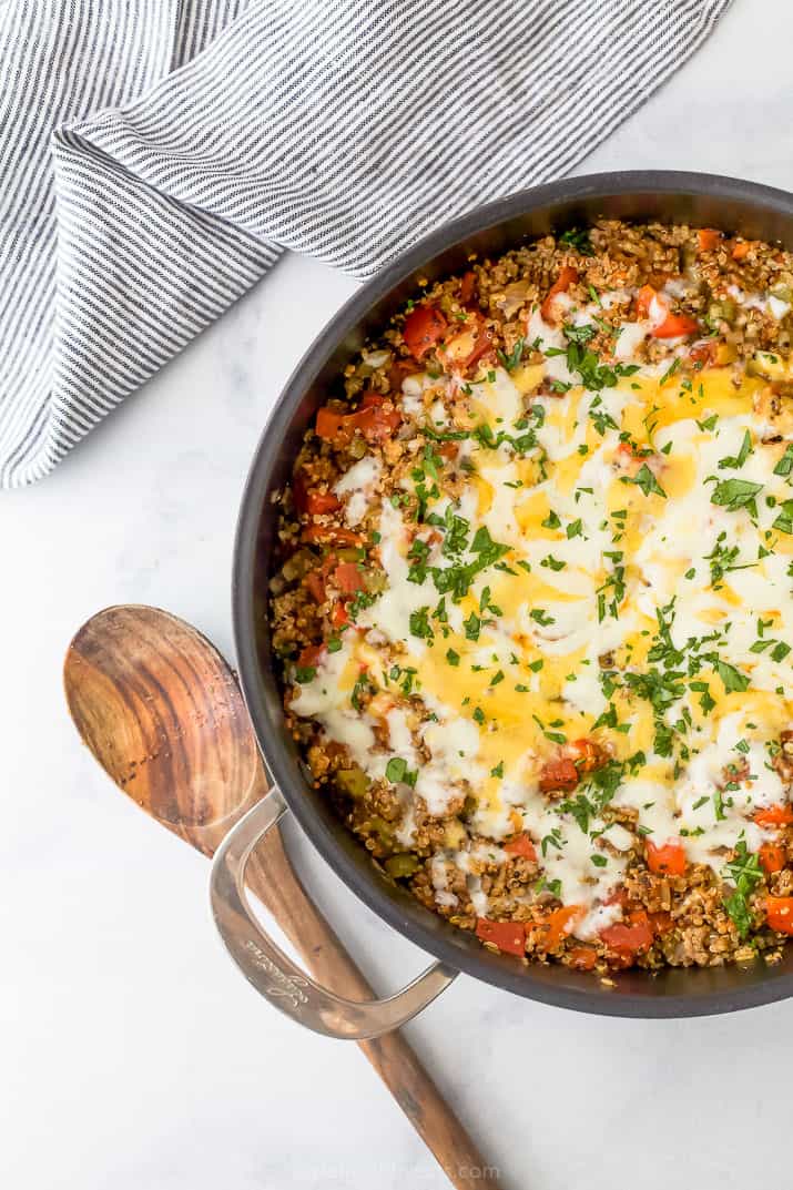 easy one pot quinoa stuffed pepper recipes in a pan with a wooden spoon on the side