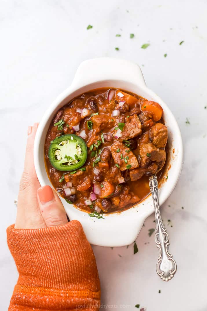 The best instant pot chili recipe in a bowl with a hand holding the bowl.