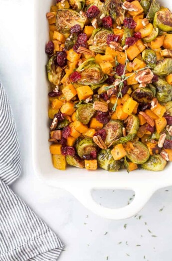 maple dijon roasted butternut squash brussel sprout salad in a baking dish