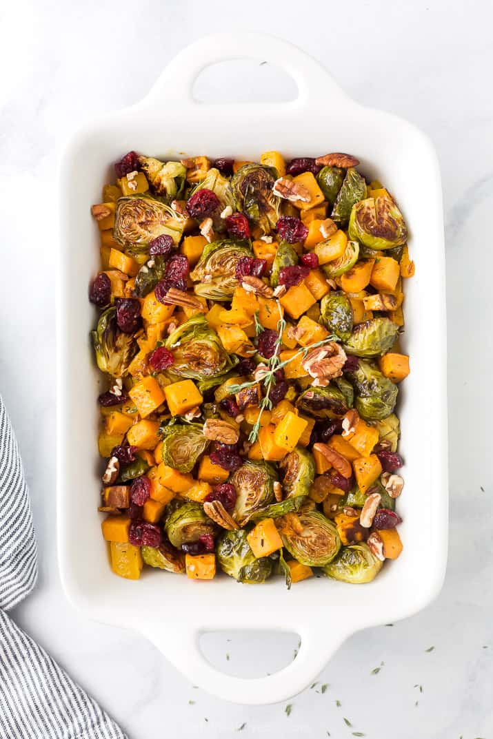 maple dijon roasted butternut squash brussel sprout salad in a baking dish