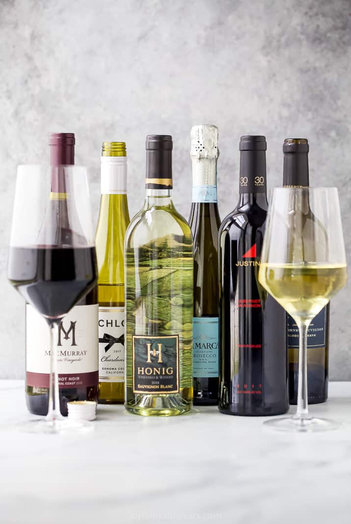 red and white wine bottles lined up for a holiday food and wine pairing guide