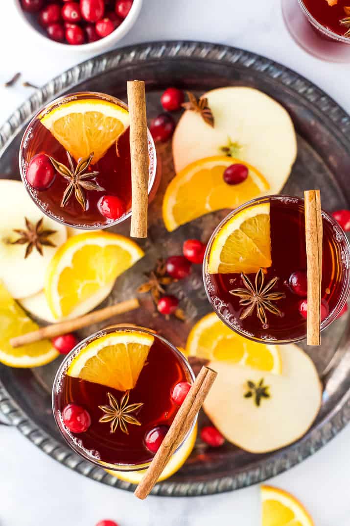 overhead photo of a glassed filled with spiked cranberry mulled apple cider