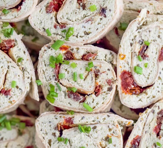 the best pesto chicken pinwheel recipe stacked on a platter