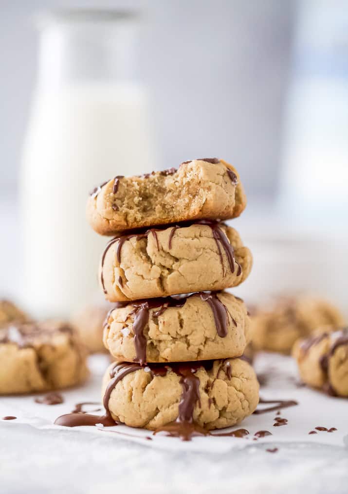 vegan peanut butter cookies with a chocolate drizzle stacked on top of each other
