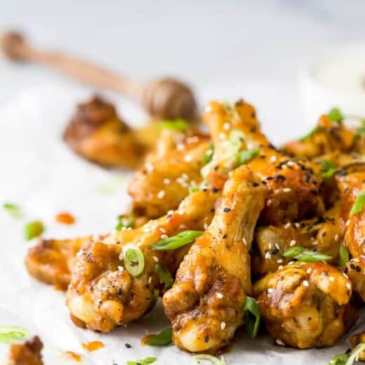 crispy baked korean bbq chicken wings with green onions and sesame seeds on top