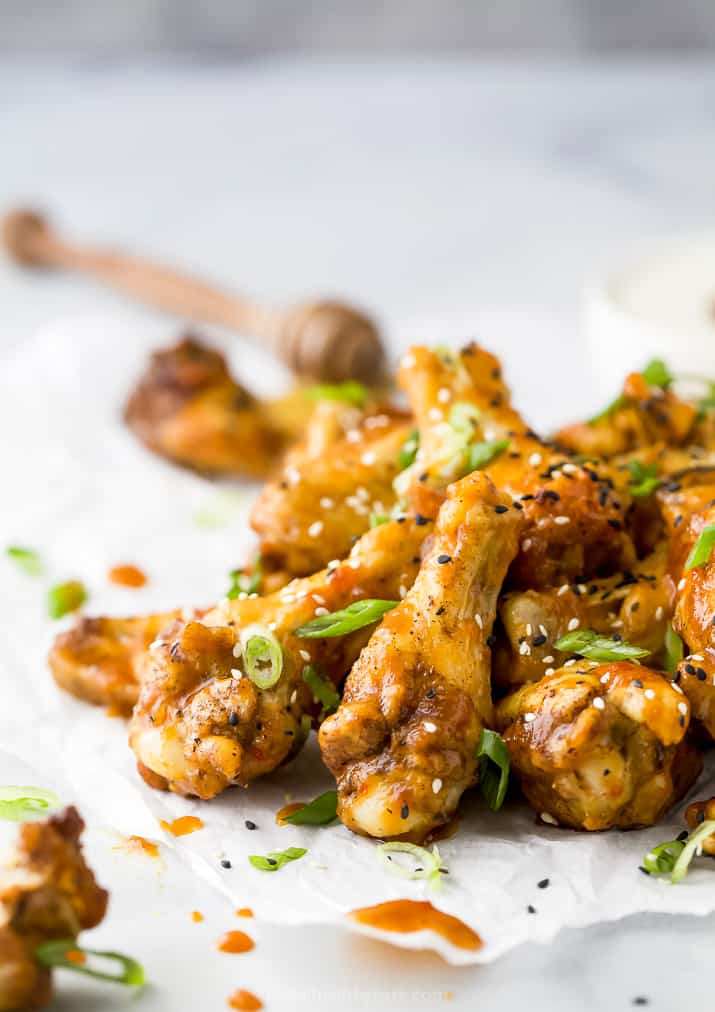 crispy baked korean bbq chicken wings with green onions and sesame seeds on top