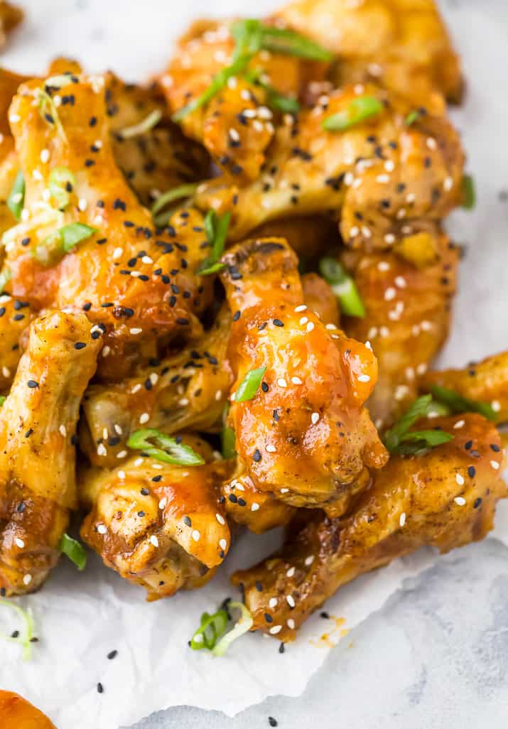 close up of crispy baked korean bbq chicken wings with green onions on top