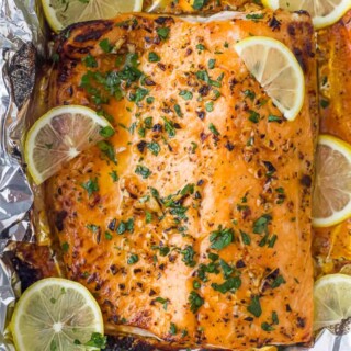overhead photo of easy 20 minute garlic butter baked salmon in foil recipe with lemons on top