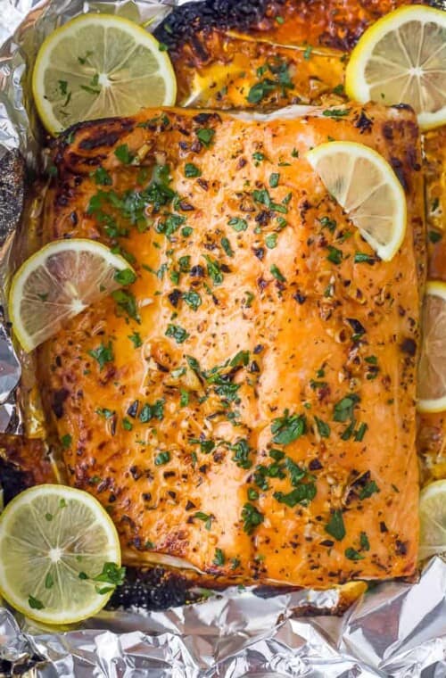 overhead photo of easy 20 minute garlic butter baked salmon in foil recipe with lemons on top