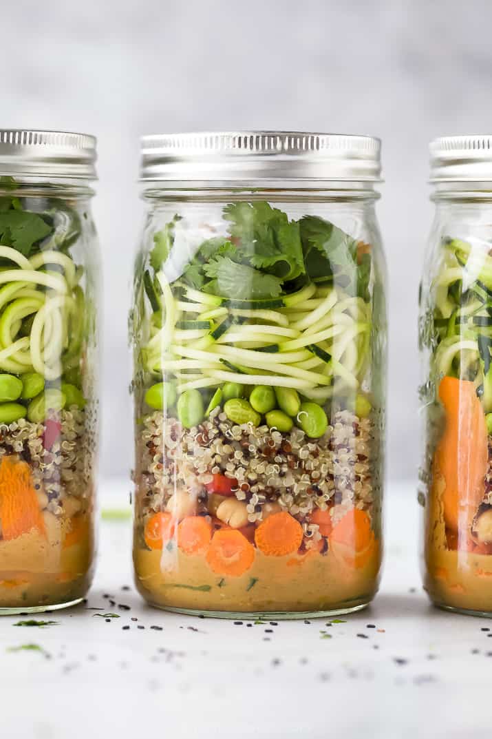 close up of crunchy vegetarian thai quinoa salad with peanut dressing in mason jars