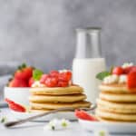 a stack of healthy fluffy pancakes with strawberry compote on top