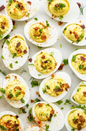 close up photo of classic deviled eggs recipe topped with bacon and chives