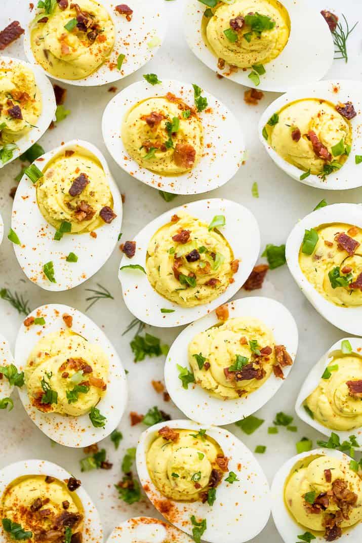 close up photo of classic deviled eggs recipe topped with bacon and chives