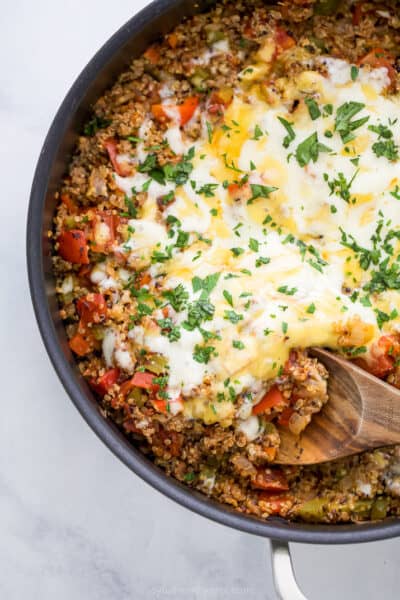 easy one pot quinoa stuffed pepper recipe in a skillet topped with cheese
