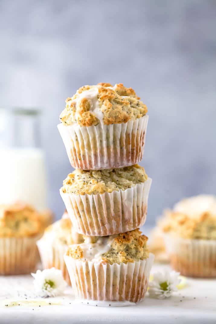 close up of moist gluten free lemon poppyseed muffins stacked on top of each other