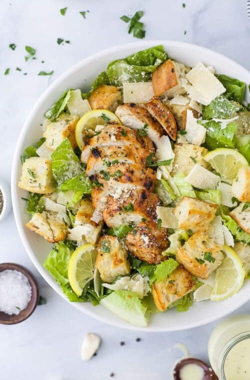 a bowl filled with easy grilled chicken caesar salad with homemade dressing