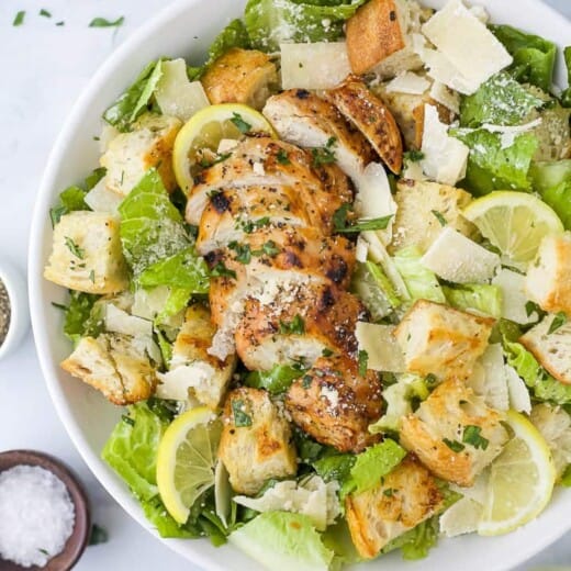 a bowl filled with easy grilled chicken caesar salad with homemade dressing