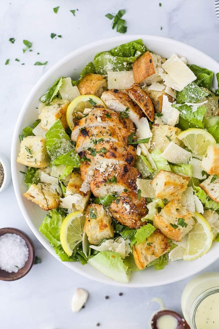a bowl filled with chicken Caesar salad