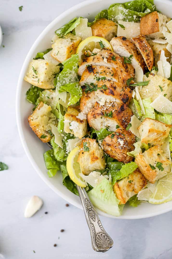 close up of a bowl filled with easy grilled chicken caesar salad with homemade dressing