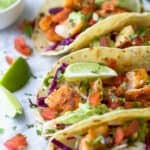 epic baja fish tacos topped with cabbage slaw and avocado crema