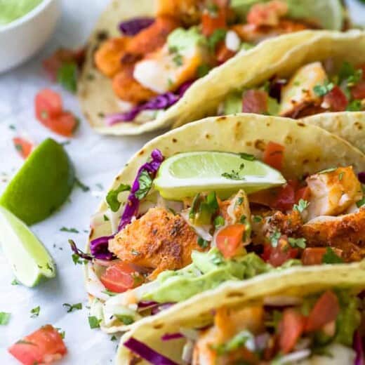 epic baja fish tacos topped with cabbage slaw and avocado crema