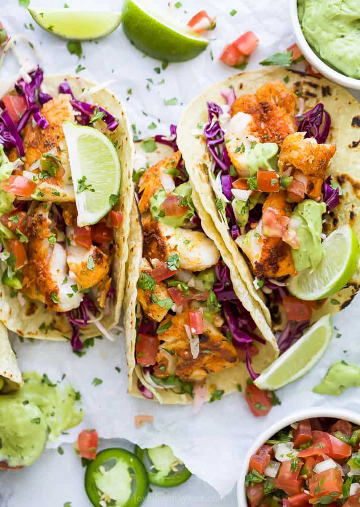 overhead photo of epic baja fish tacos with an avocado crema and lime wedges