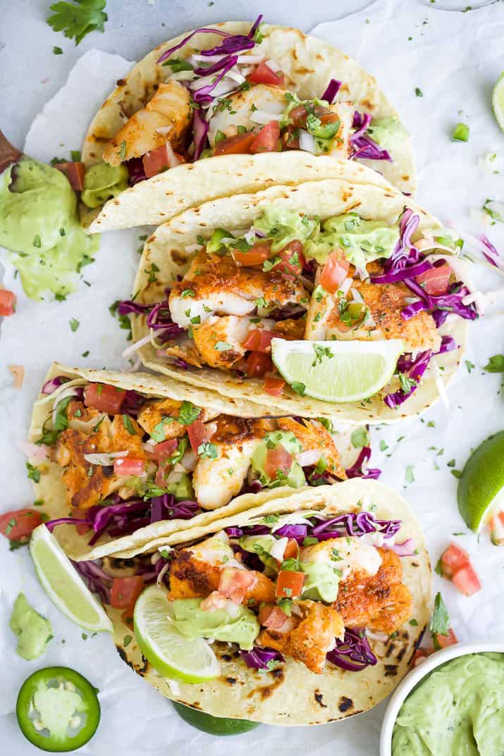 overhead photo of epic baja fish tacos topped with cabbage slaw and avocado crema