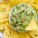 the best guacamole recipe in a bowl with tortilla chips around it