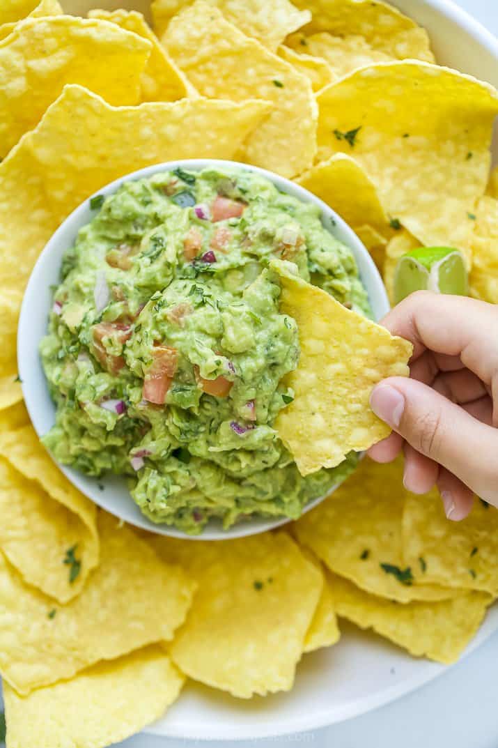 scooping guacamole with a chip