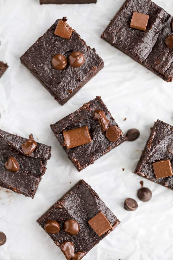 overhead photo of double chocolate avocado brownies scattered on a board