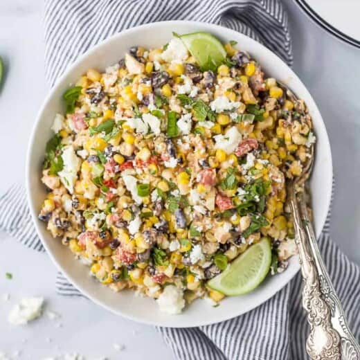 a bowl of grilled mexican street corn salad topped with fresh cilantro