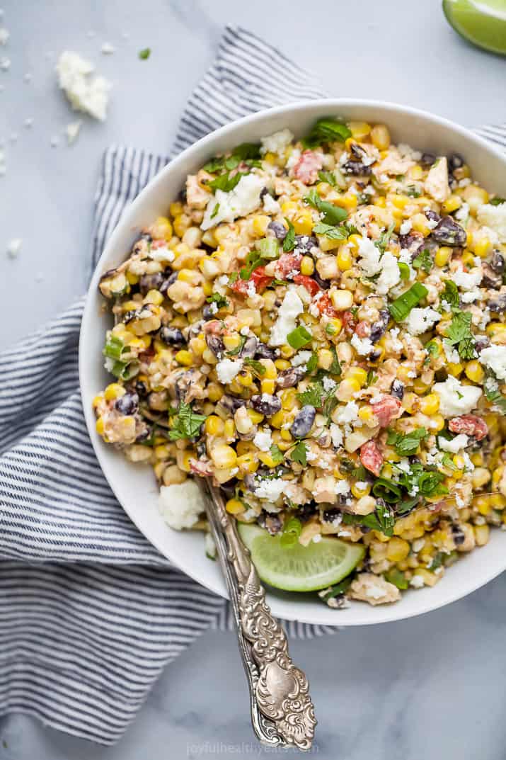 a bowl filled with best grilled mexican street corn salad topped with cilantro