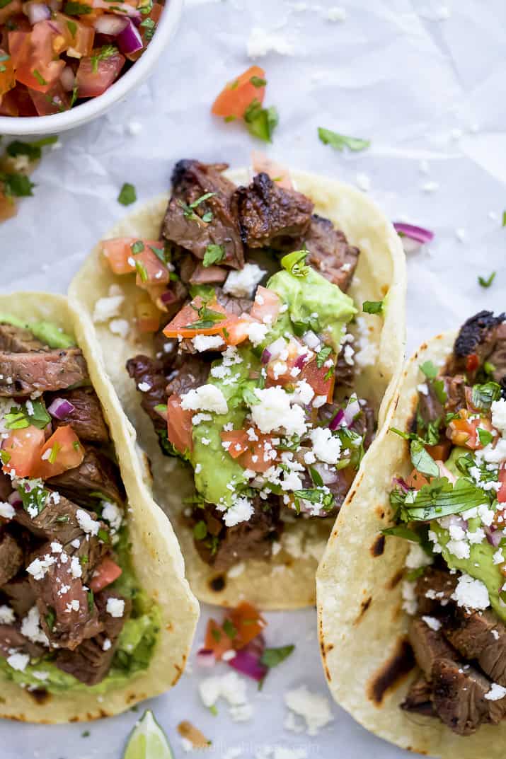 corn tortillas filled with marinated carne asada meat and avocado crema