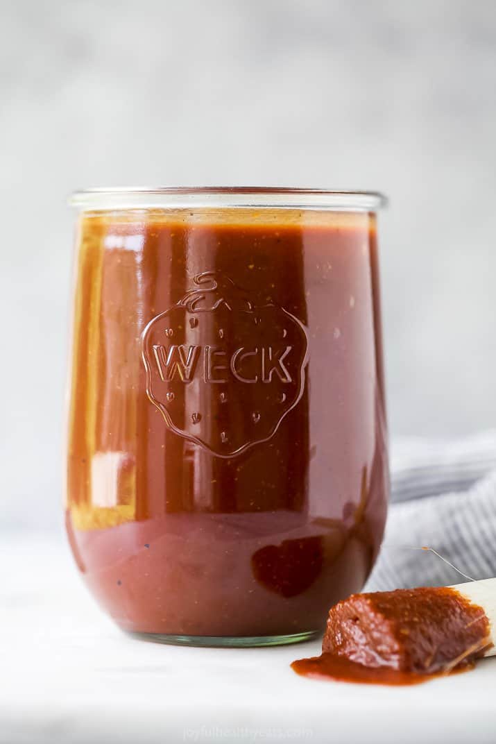 homemade bbq sauce in a weck jar with a bbq sauce drenched brush