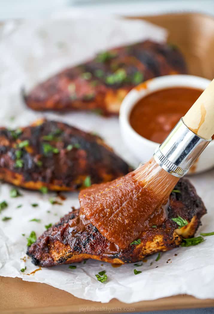 brushing homemade BBQ Sauce on grilled chicken