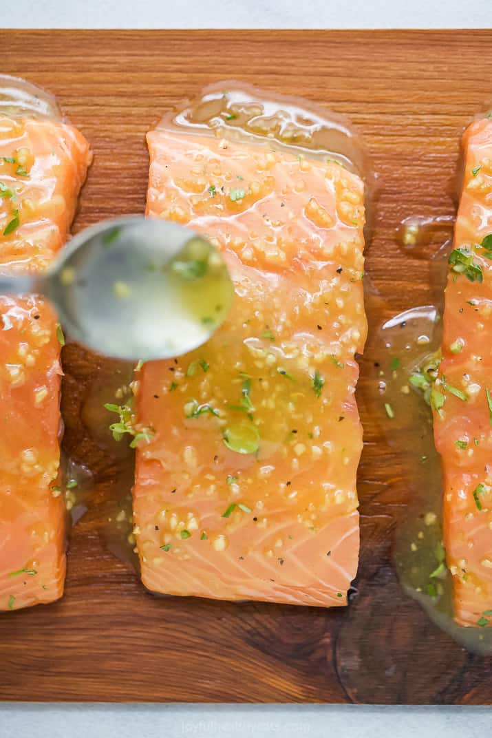 honey garlic sauce being poured on cedar plank salmon