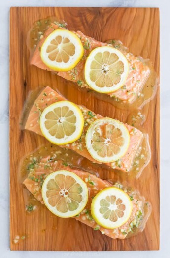 honey garlic cedar plank salmon topped with lemon slices