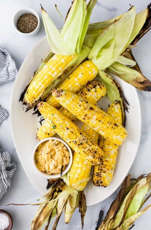 A plate filled with grilled corn on the cob with honey chipotle butter.