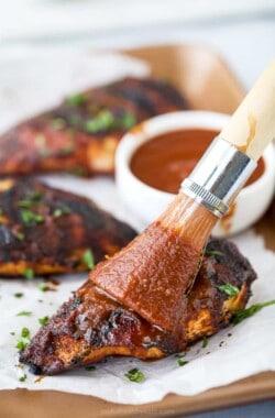 bbq sauce being brushed on bbq chicken